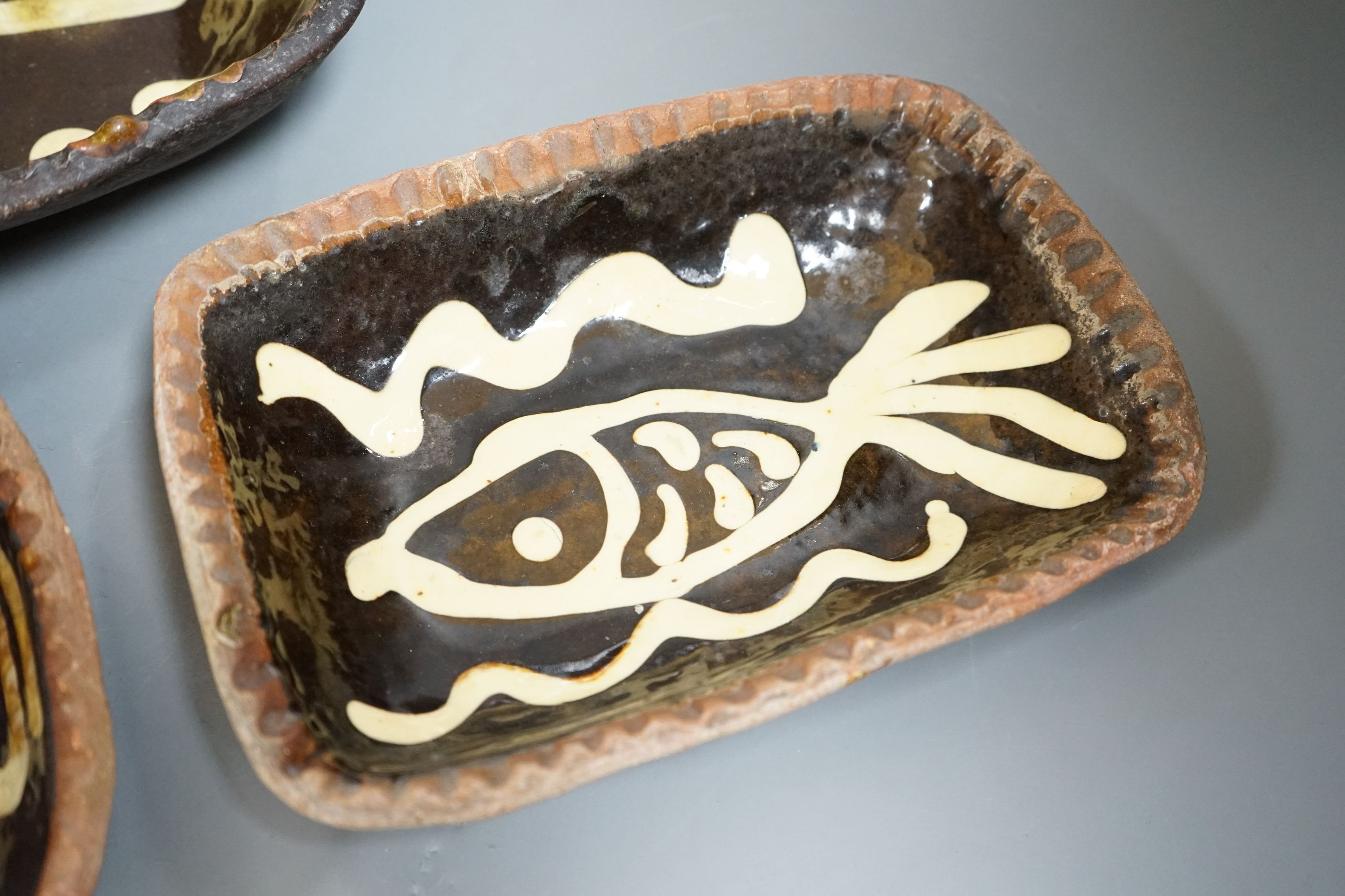 Winchcombe pottery, three press moulded slipware dishes, one with Ray Finch maker’s stamp, largest 26.5cm wide